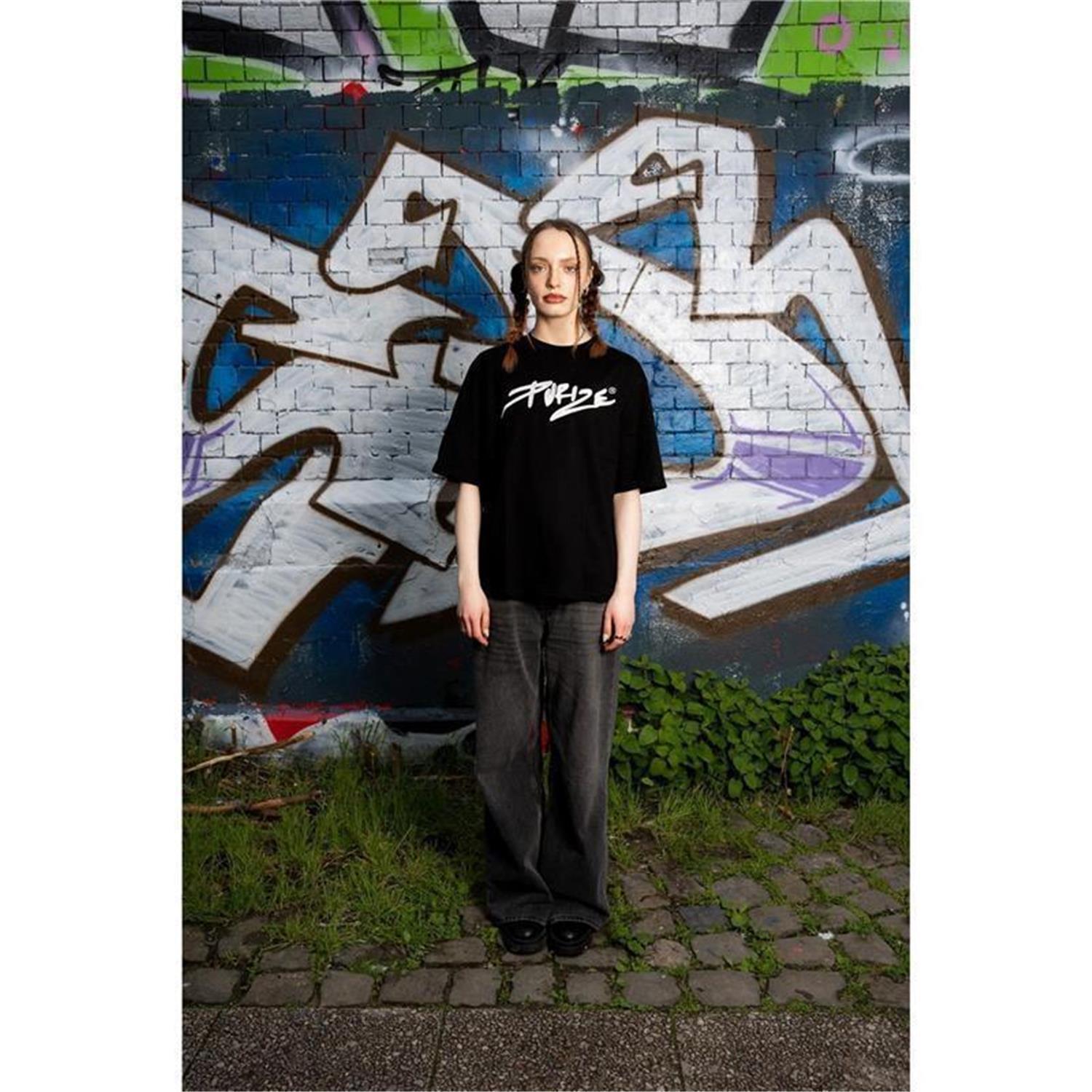 PURIZE T-Shirt in Schwarz, Detailansicht des weiß gestickten 3D-PURIZE-Logos auf der Brust, getragen von Frau